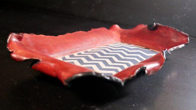 Tray from a low angle for dramatic effect, showing the torn edges close-up, and the black underside